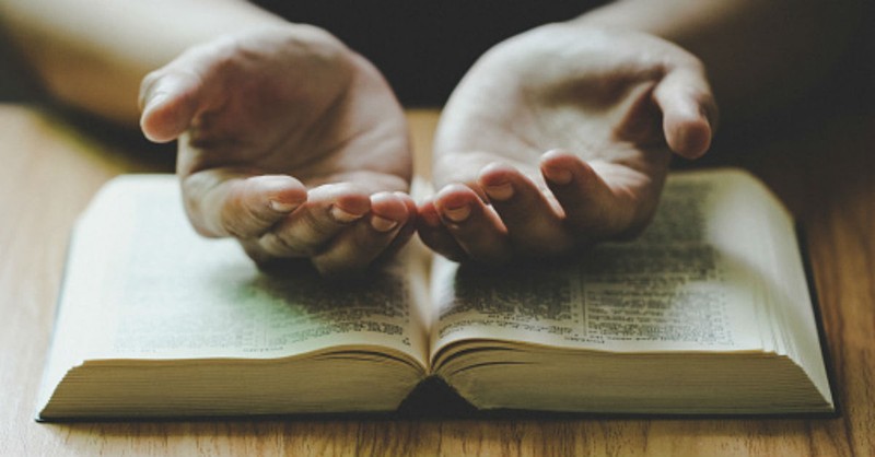 open hands on a Bible